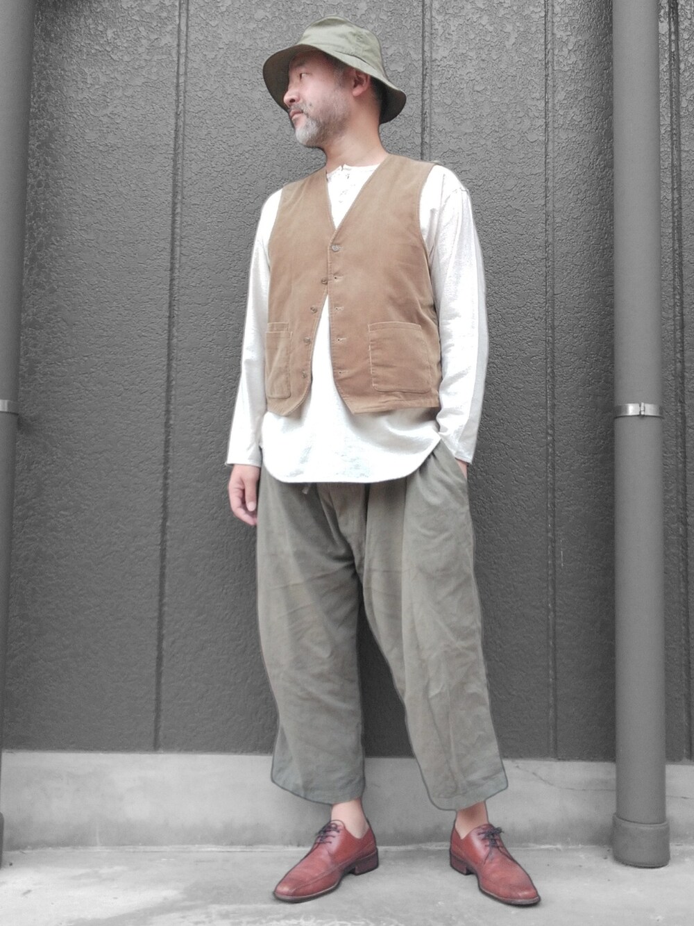 グリーン系のその他パンツ、ホワイト系のTシャツ/カットソー、ベージュ系のベストを着用したメンズの秋コーディネートの3枚目の写真