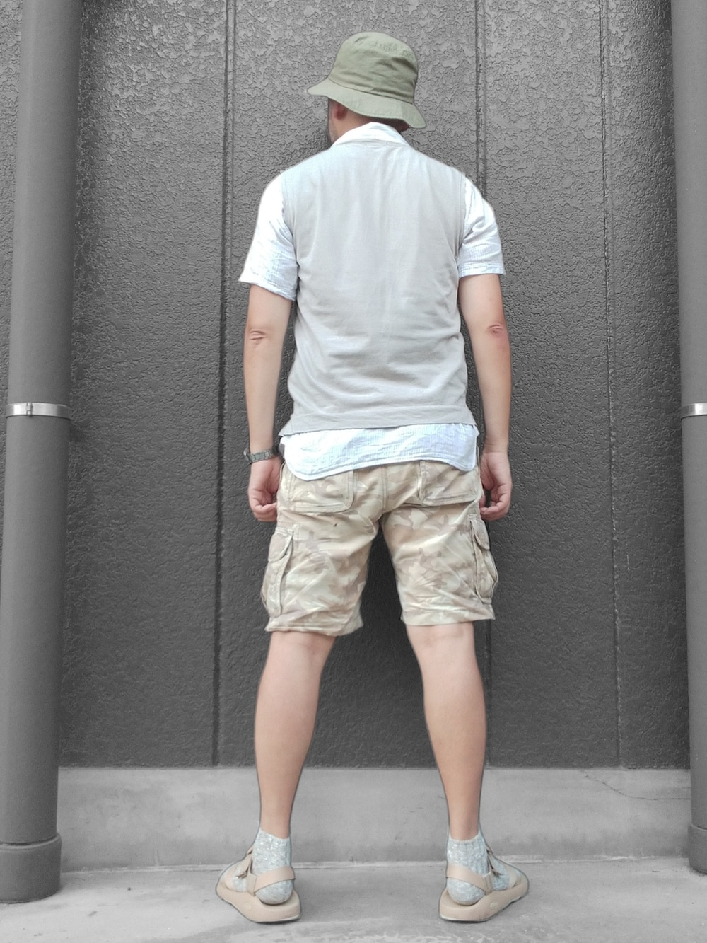 グレー系のベスト、ベージュ系のカーゴパンツ、ベージュ系のサンダルを着用したメンズの夏コーディネートの5枚目の写真