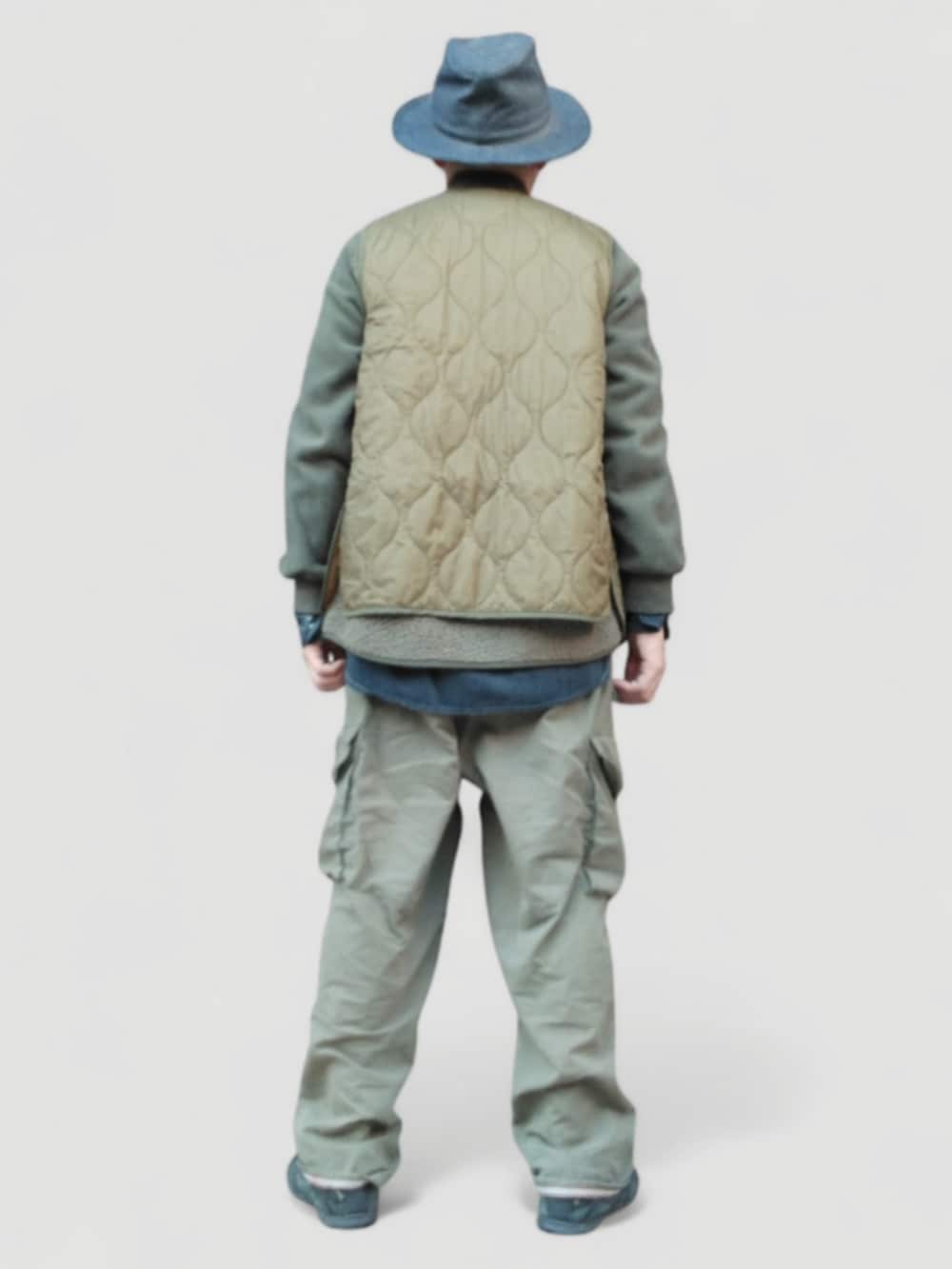 グリーン系のカーゴパンツ、グリーン系のベスト、ブルー系のハットを着用したメンズの冬コーディネートの5枚目の写真