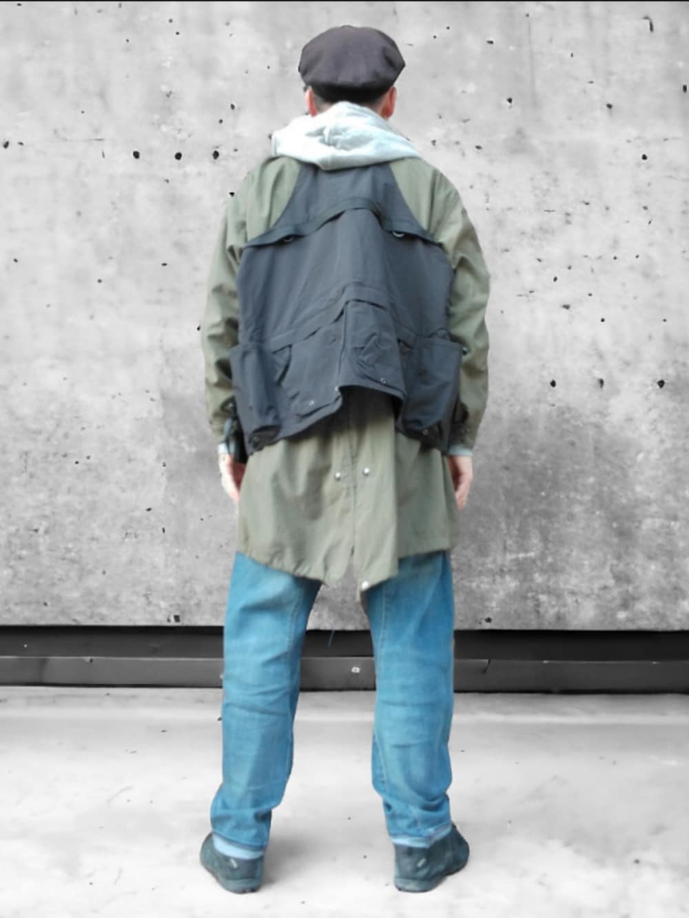ブルー系のデニムパンツ、ブラック系のスニーカー、グリーン系のモッズコートを着用したメンズの冬コーディネートの5枚目の写真