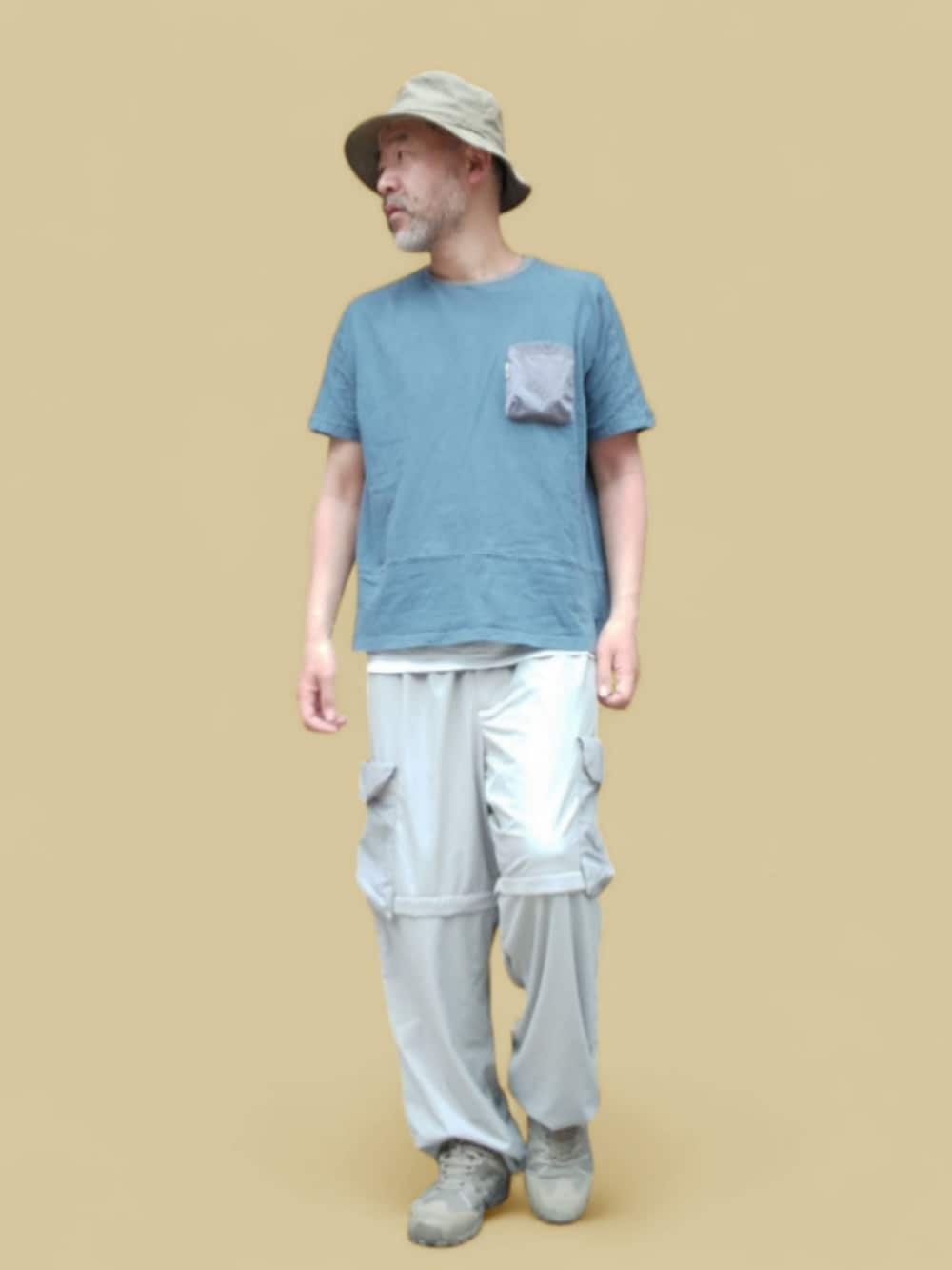 ブルー系のTシャツ/カットソー、グレー系のカーゴパンツ、グリーン系のスニーカーを着用したメンズの夏コーディネートの2枚目の写真