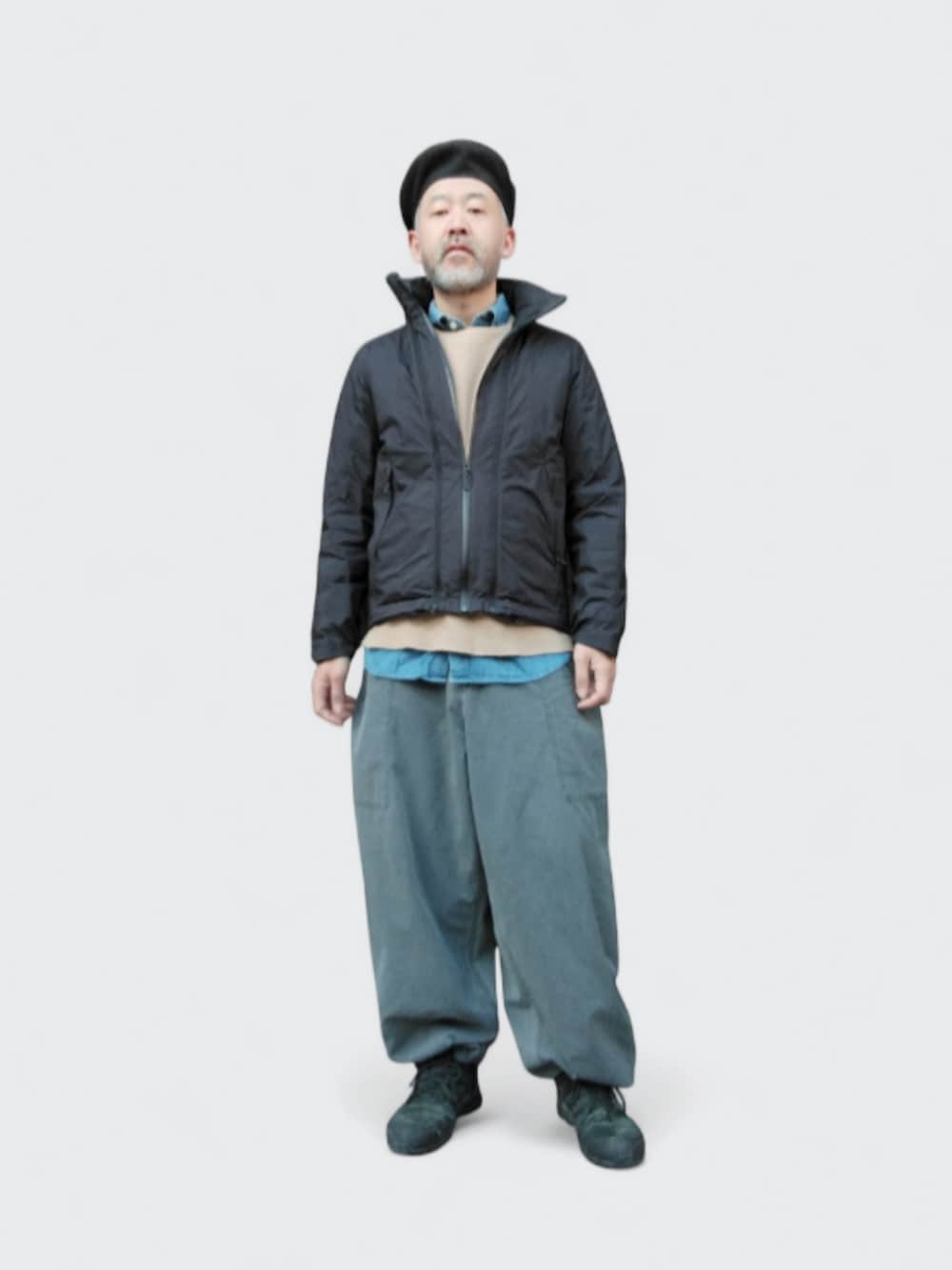 グレー系のパンツ、ブラック系のダウンジャケット/コート、ブラック系のスニーカーを着用したメンズの冬コーディネートの3枚目の写真