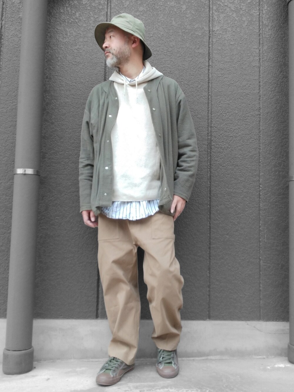 ベージュ系のパンツ、グリーン系のスニーカー、ベージュ系のパーカーを着用したメンズの春コーディネートの3枚目の写真