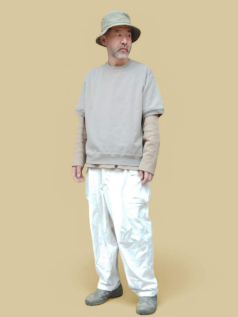 ホワイト系のカーゴパンツ、グリーン系のスニーカー、ベージュ系のTシャツ/カットソーを着用したメンズの春コーディネートの4枚目の写真