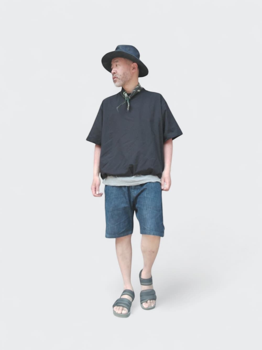 ブルー系のデニムパンツ、ブラック系のTシャツ/カットソー、グリーン系のサンダルを着用したメンズの春コーディネートの3枚目の写真