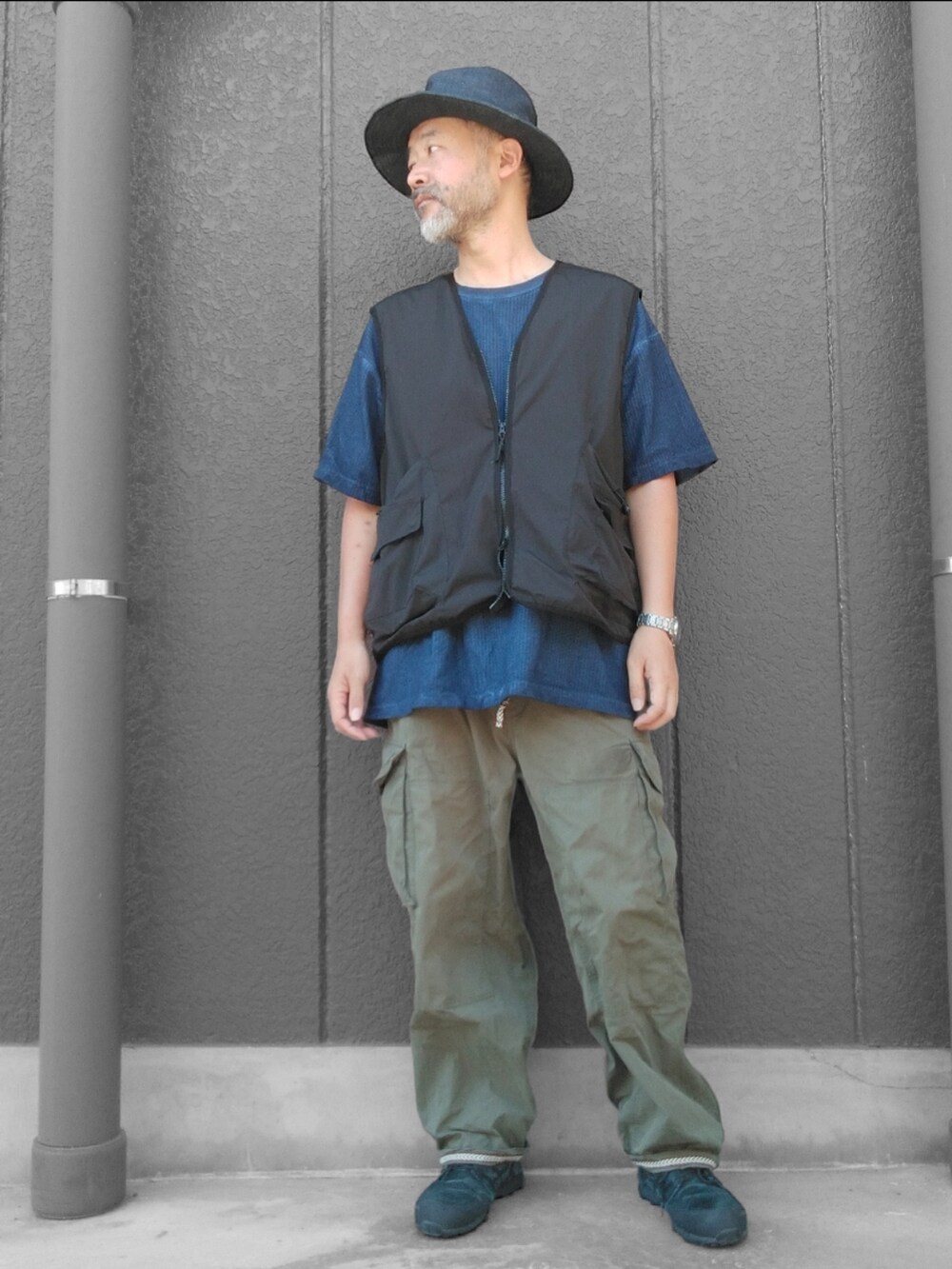 グリーン系のカーゴパンツ、ブラック系のスニーカー、ブルー系のTシャツ/カットソーを着用したメンズの夏コーディネートの2枚目の写真