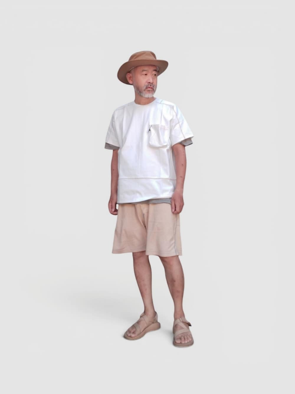 イエロー系のパンツ、ベージュ系のサンダル、ホワイト系のTシャツ/カットソーを着用したメンズの夏コーディネートの4枚目の写真