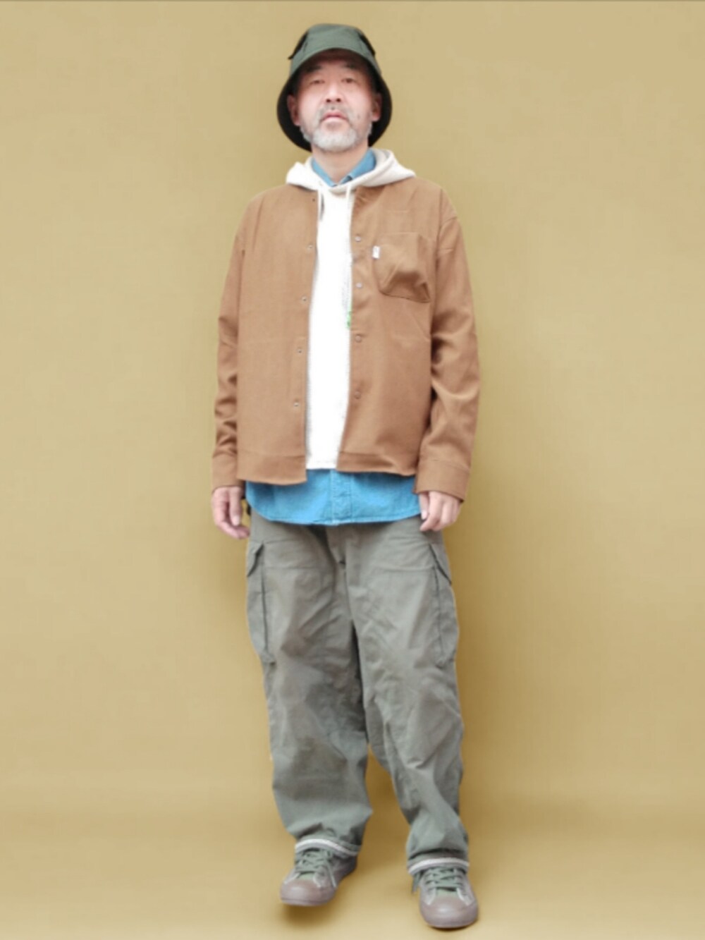 グリーン系のカーゴパンツ、グリーン系のスニーカー、ブラウン系のシャツ/ブラウスを着用したメンズの秋コーディネートの3枚目の写真