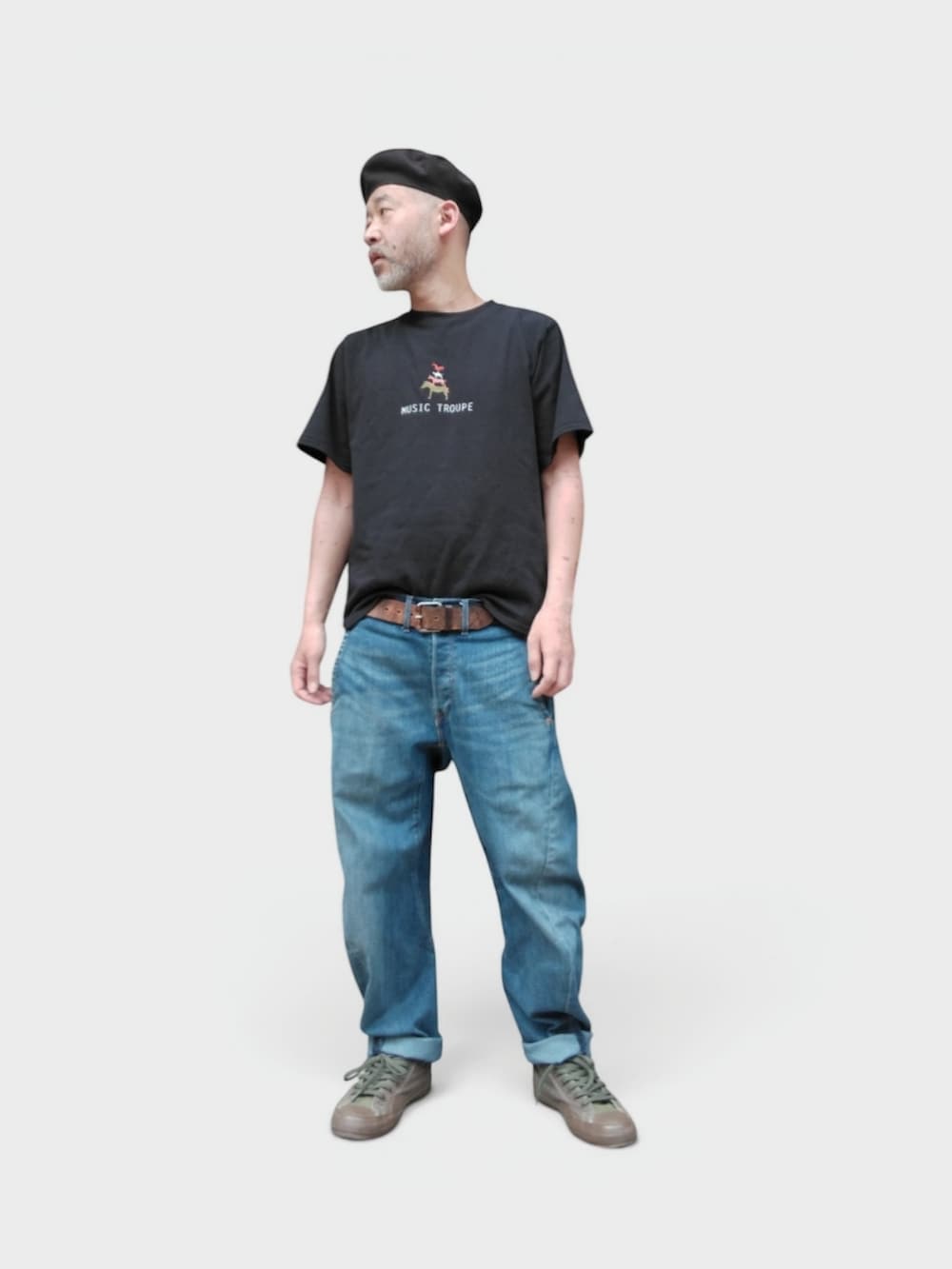 グリーン系のスニーカー、ブルー系のデニムパンツ、ブラック系のTシャツ/カットソーを着用したメンズの夏コーディネートの4枚目の写真