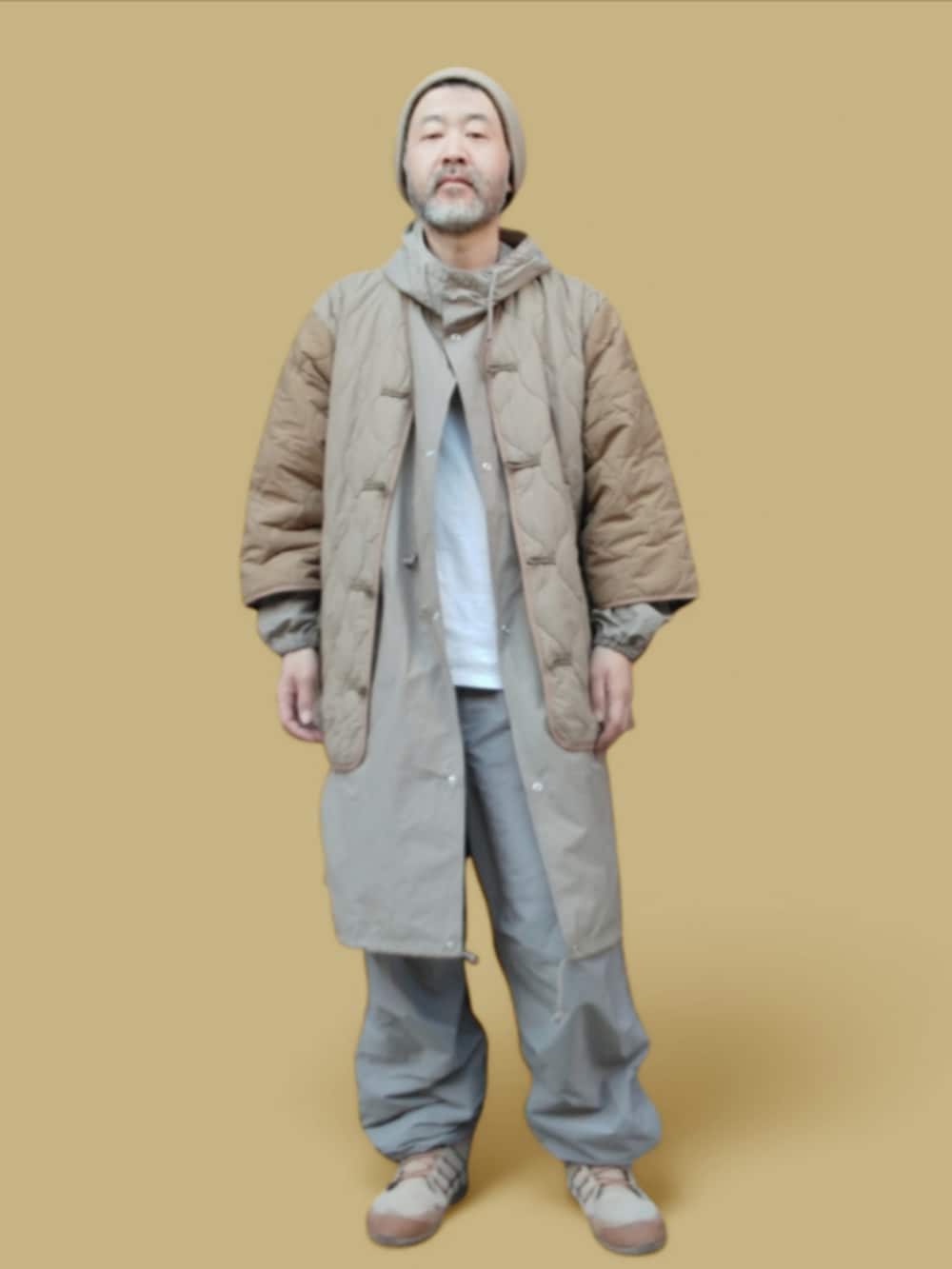 グレー系のパンツ、ベージュ系のスニーカー、ベージュ系のジャケット/アウターを着用したメンズの冬コーディネートの3枚目の写真