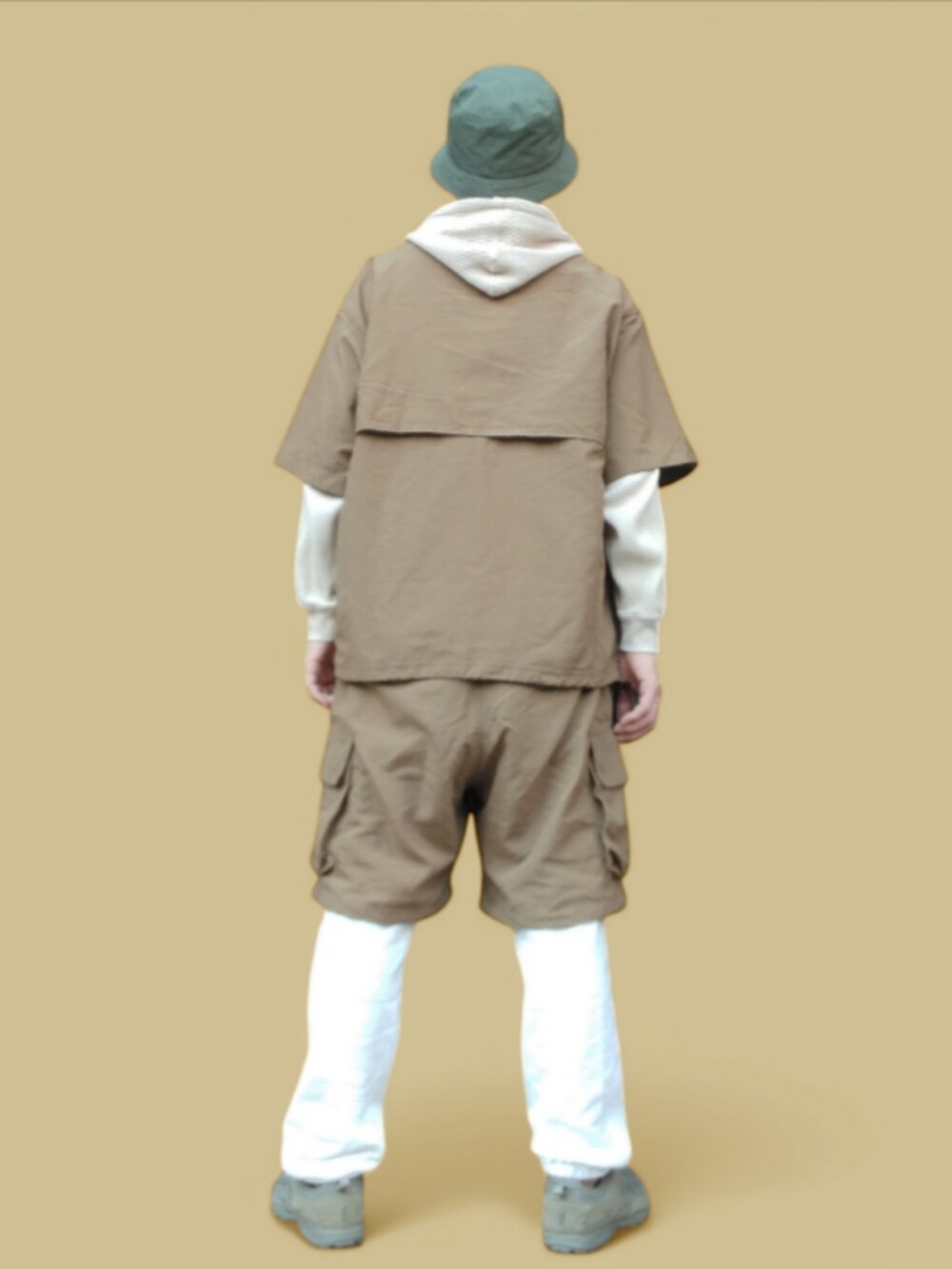 ホワイト系のスウェットパンツ、ベージュ系のパーカー、グリーン系のスニーカーを着用したメンズの冬コーディネートの5枚目の写真