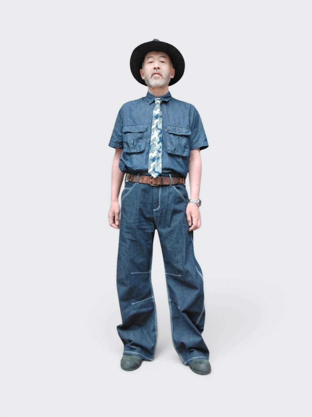 ブルー系のデニムパンツ、ブラック系のスニーカー、ブルー系のシャツ/ブラウスを着用したメンズの夏コーディネートの2枚目の写真