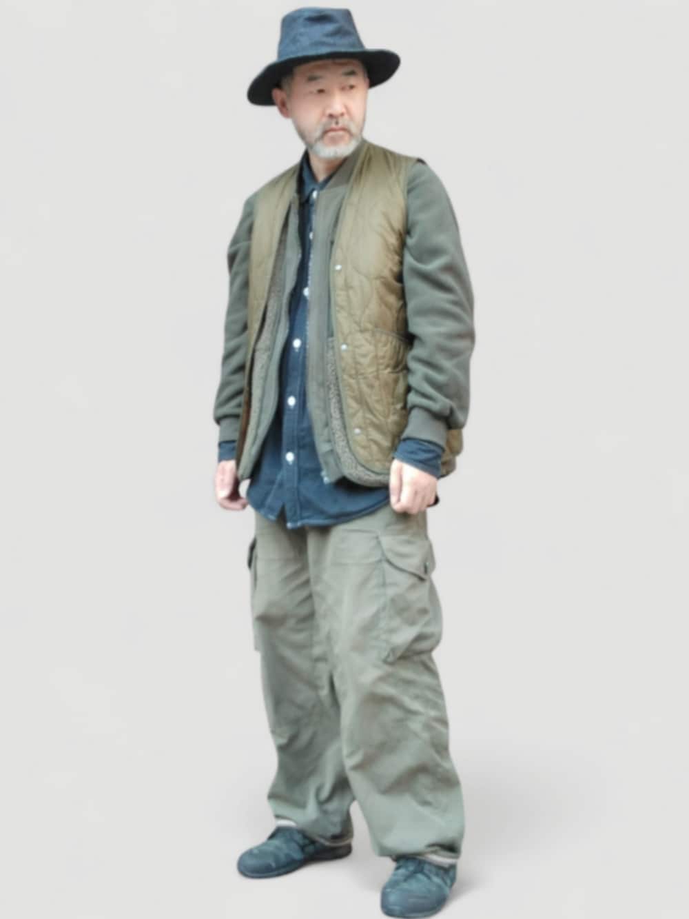 グリーン系のカーゴパンツ、グリーン系のベスト、ブルー系のハットを着用したメンズの冬コーディネートの3枚目の写真