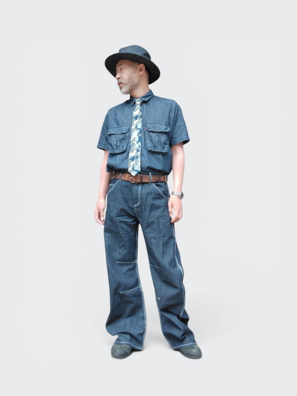 ブルー系のデニムパンツ、ブラック系のスニーカー、ブルー系のシャツ/ブラウスを着用したメンズの夏コーディネートの4枚目の写真
