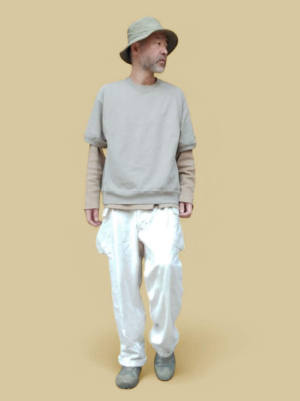 ホワイト系のカーゴパンツ、グリーン系のスニーカー、ベージュ系のTシャツ/カットソーを着用したメンズの春コーディネートの3枚目の写真