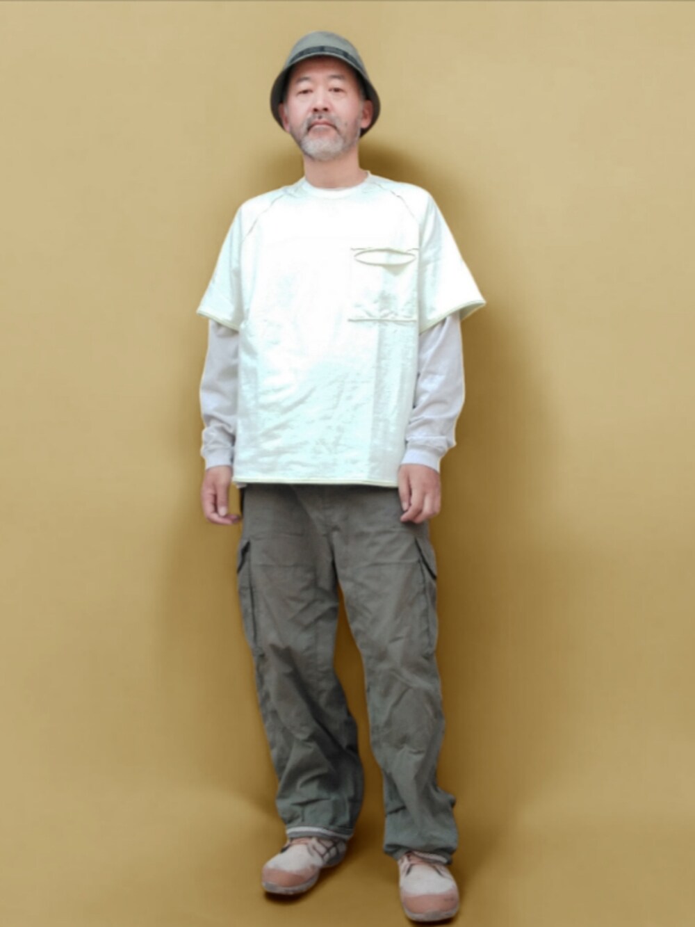 グリーン系のカーゴパンツ、ベージュ系のスニーカー、ホワイト系のTシャツ/カットソーを着用したメンズの夏コーディネートの3枚目の写真