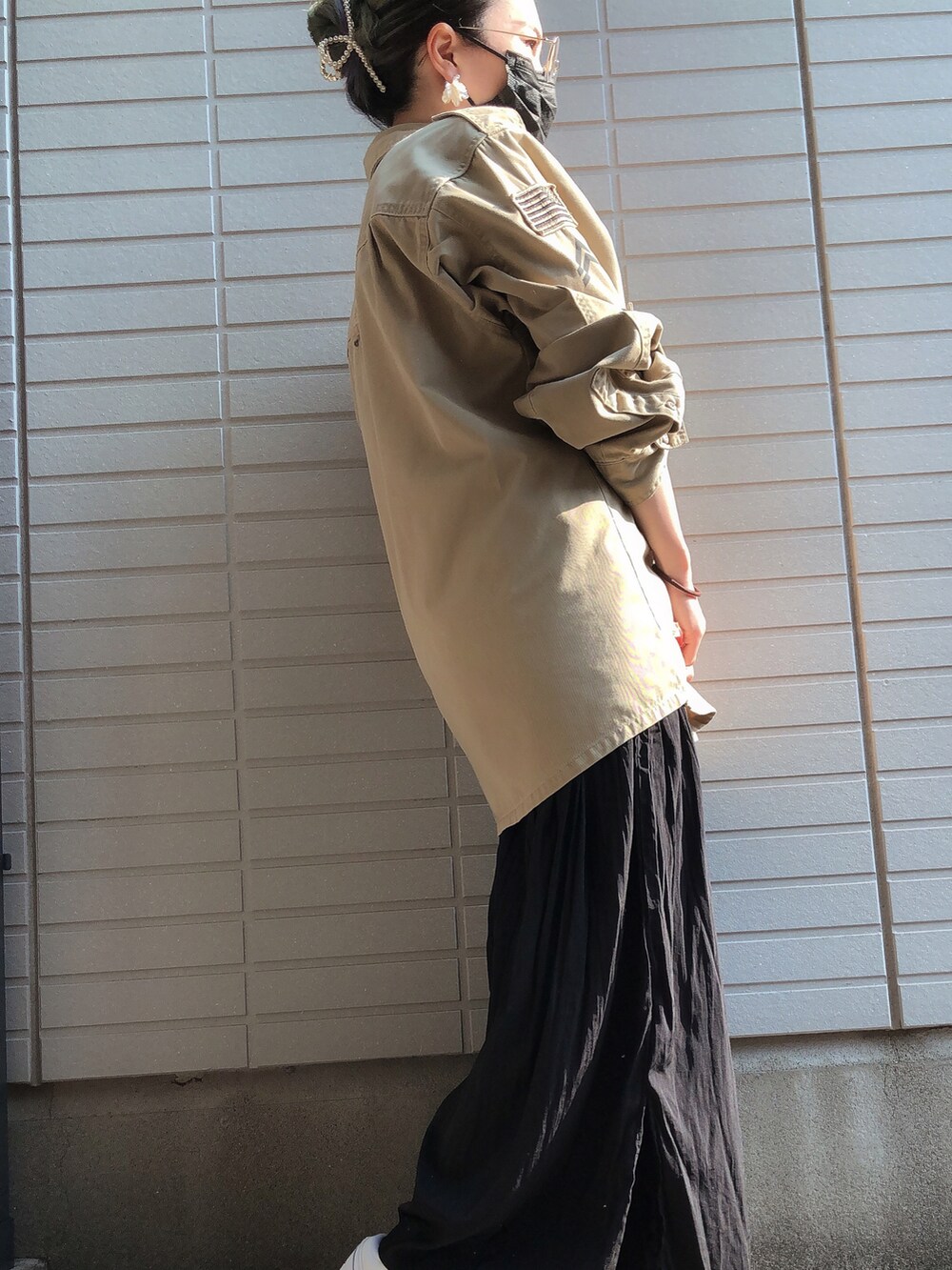 ブラック系のその他パンツ、ホワイト系のスニーカー、ベージュ系のミリタリージャケットを着用したレディースの秋コーディネートの2枚目の写真