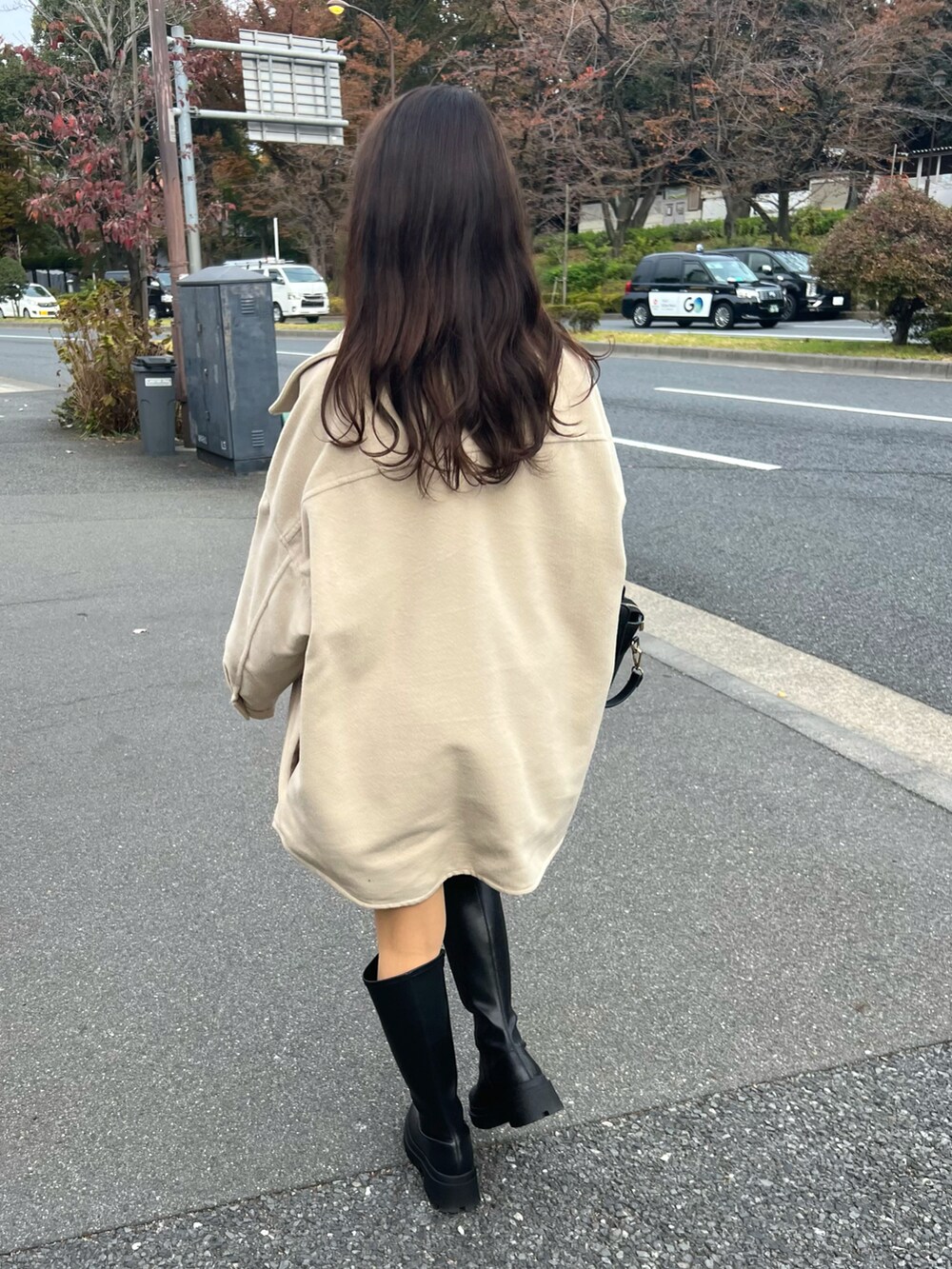 ブラック系のブーツ、ブラウン系のハンドバッグ、ブラック系のその他パンツを着用したレディースの秋コーディネートの2枚目の写真