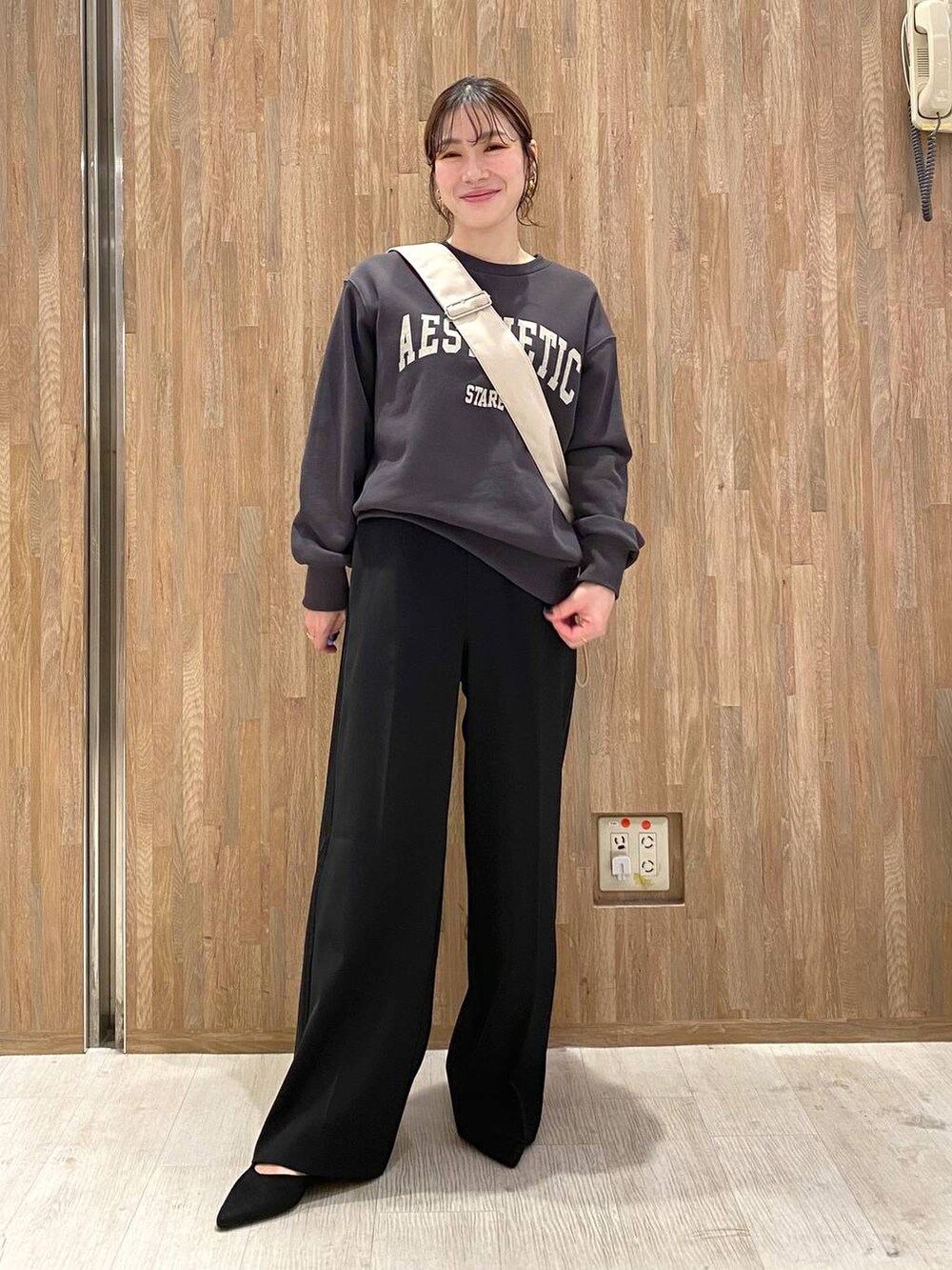 グレー系のスウェット、ブラック系のその他パンツ、ベージュ系のショルダーバッグを着用したレディースの冬コーディネートの2枚目の写真