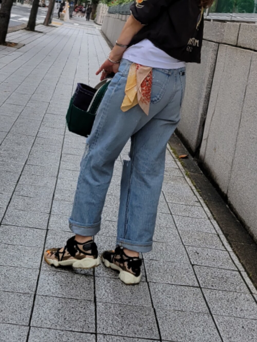 ブルー系のデニムパンツ、その他のスニーカー、グリーン系のミリタリージャケットを着用したレディースの夏コーディネートの2枚目の写真