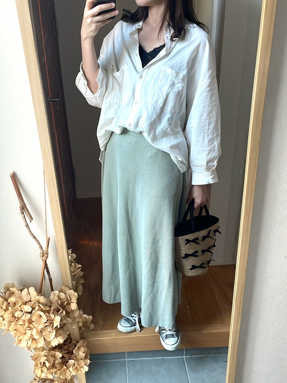 グリーン系のスカート、ホワイト系のシャツ/ブラウス、ベージュ系のトートバッグを着用したレディースの春コーディネートの2枚目の写真