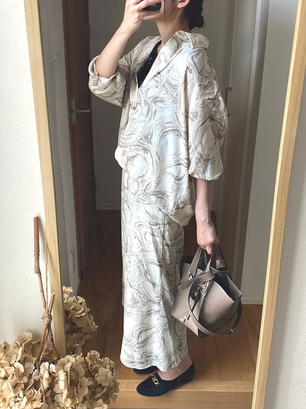 ベージュ系のショルダーバッグ、ブラック系のローファー、ベージュ系のシャツ/ブラウスを着用したレディースの春コーディネートの2枚目の写真