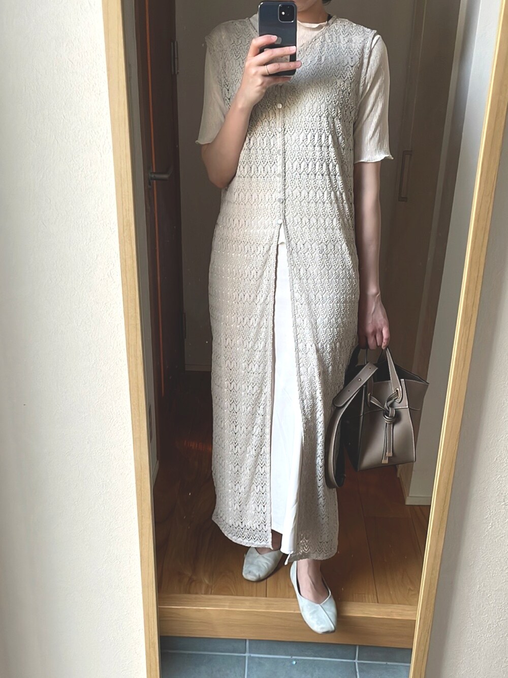 ベージュ系のショルダーバッグ、ホワイト系のシューズ、ホワイト系のスカートを着用したレディースの春コーディネートの2枚目の写真