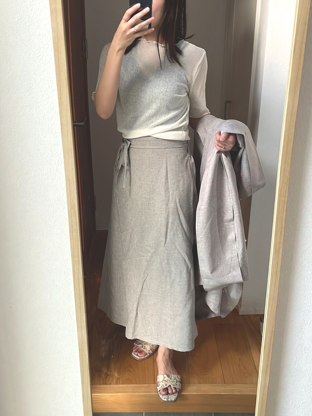 ホワイト系のトップス、ベージュ系のベスト、ベージュ系のスカートを着用したレディースの夏コーディネートの3枚目の写真