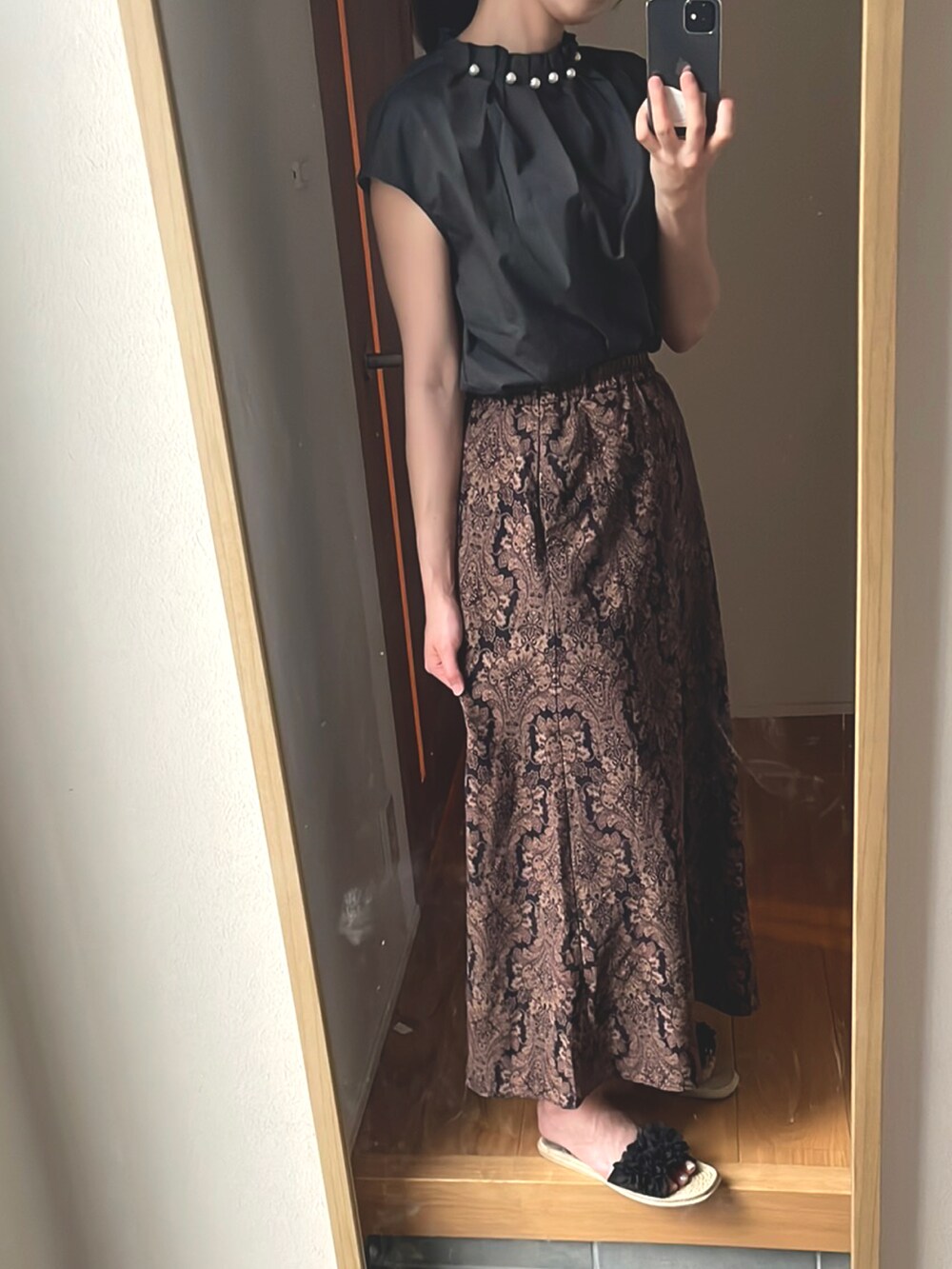 ブラック系のスカート、ブラック系のサンダル、グレー系のシャツ/ブラウスを着用したレディースの夏コーディネートの2枚目の写真