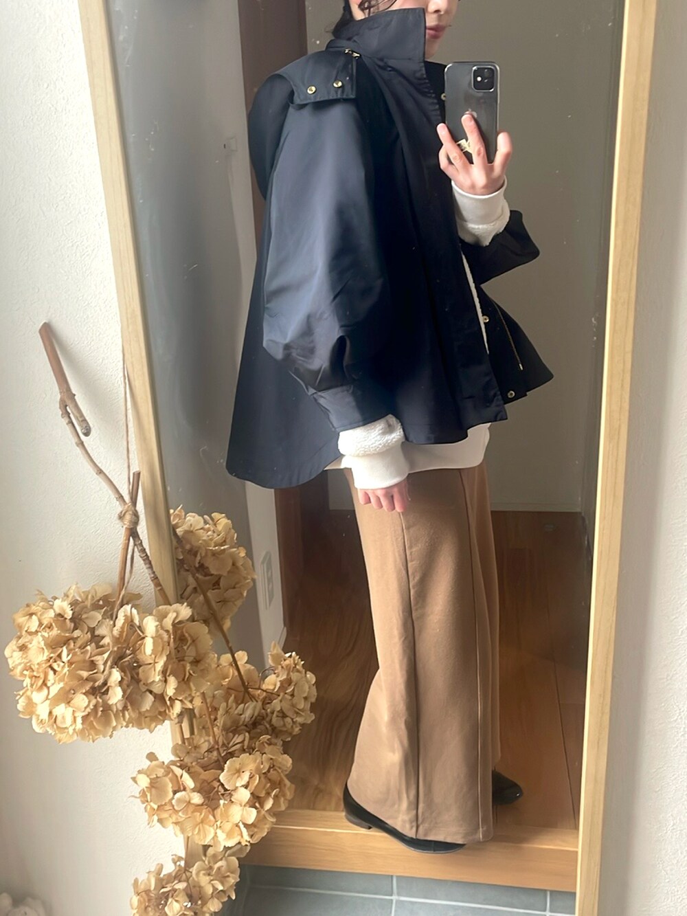 ブラック系のマウンテンパーカー、ブラック系のローファー、ホワイト系のスウェットを着用したレディースの春コーディネートの3枚目の写真