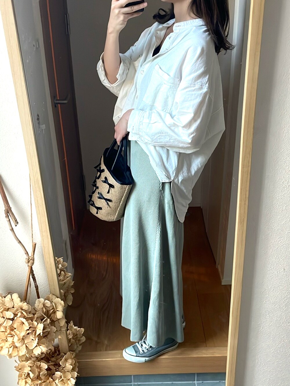 グリーン系のスカート、ホワイト系のシャツ/ブラウス、ベージュ系のトートバッグを着用したレディースの春コーディネートの4枚目の写真