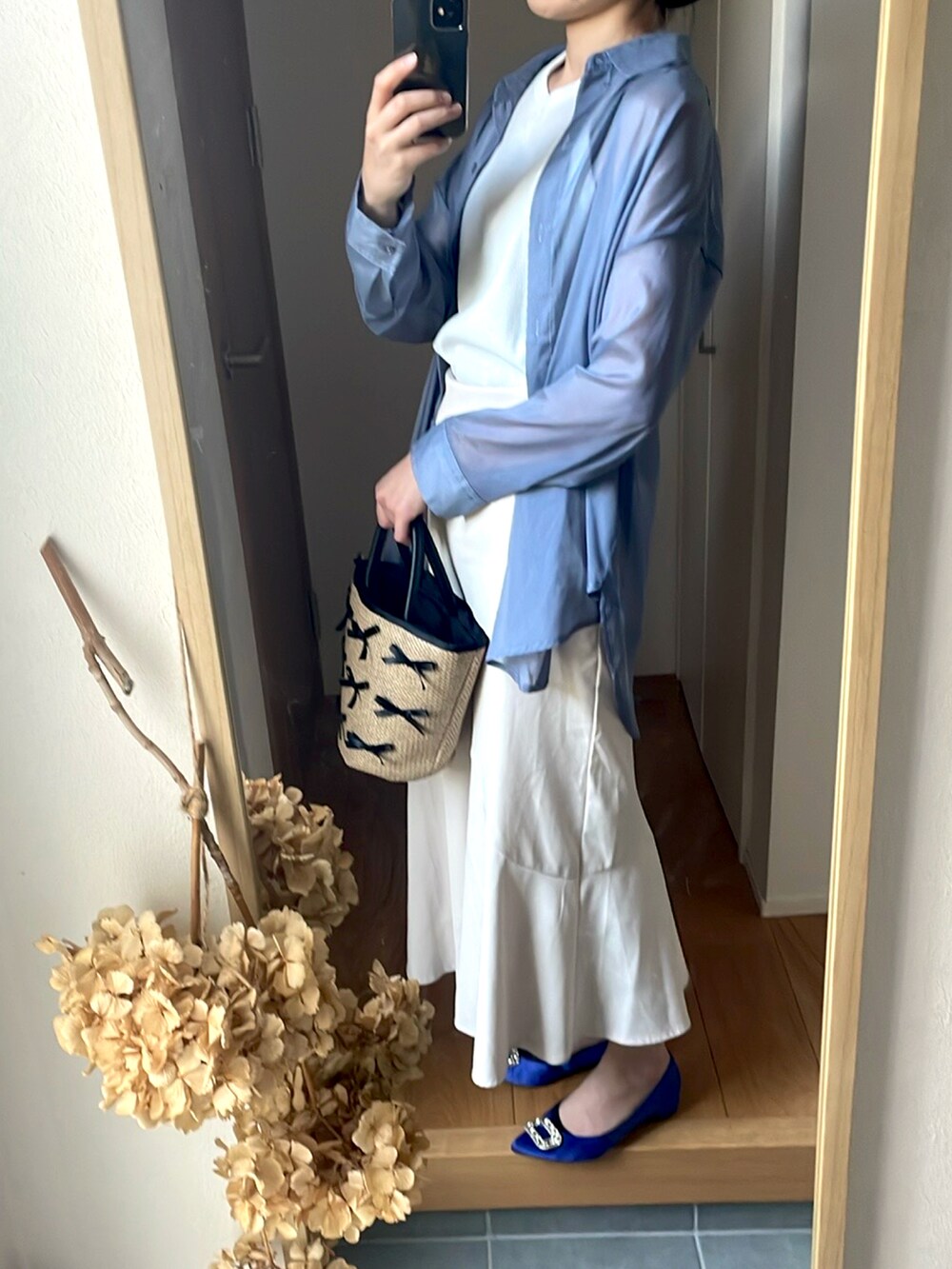 ホワイト系のスカート、ブルー系のパンプス、ベージュ系のトートバッグを着用したレディースの春コーディネートの3枚目の写真