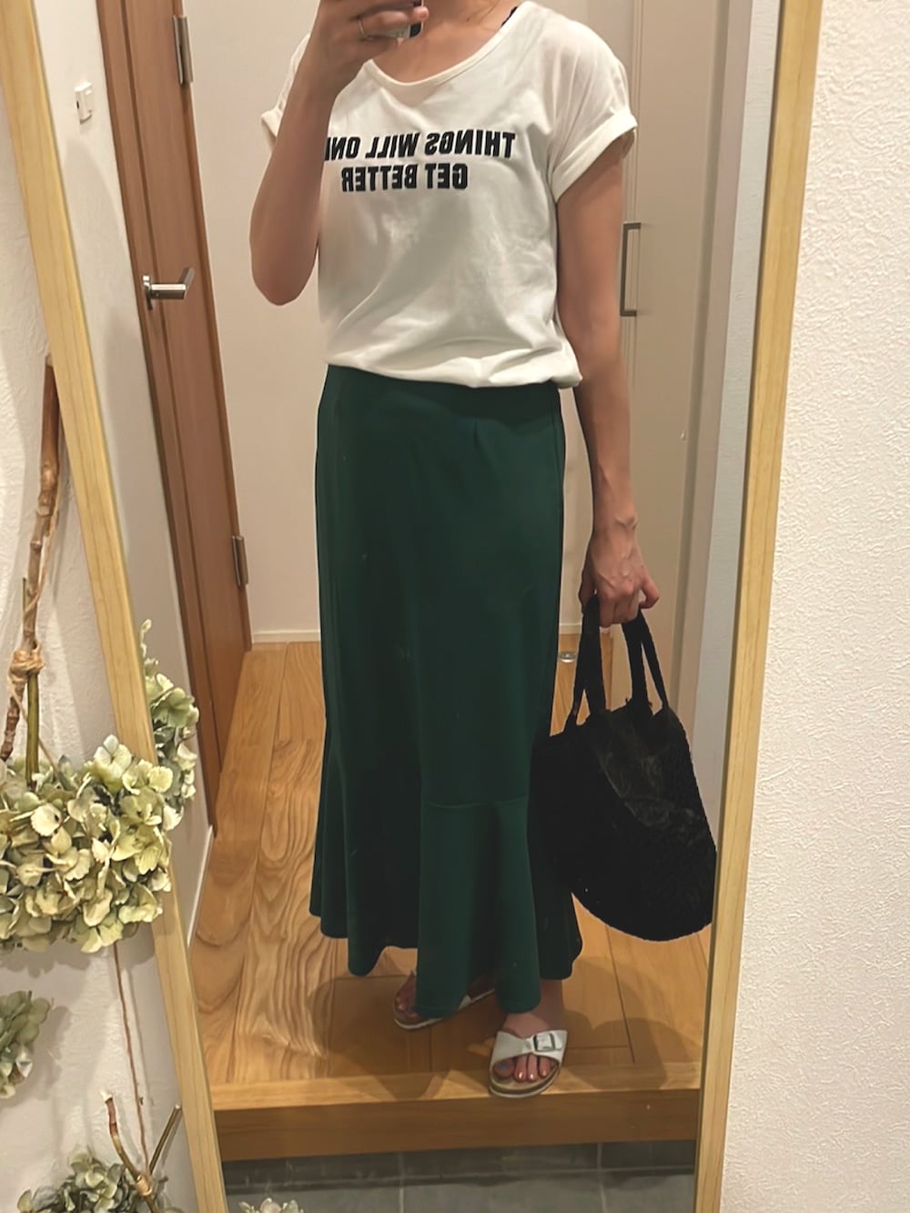 ホワイト系のTシャツ/カットソー、ブラック系のバッグ、グリーン系のスカートを着用したレディースの夏コーディネートの2枚目の写真