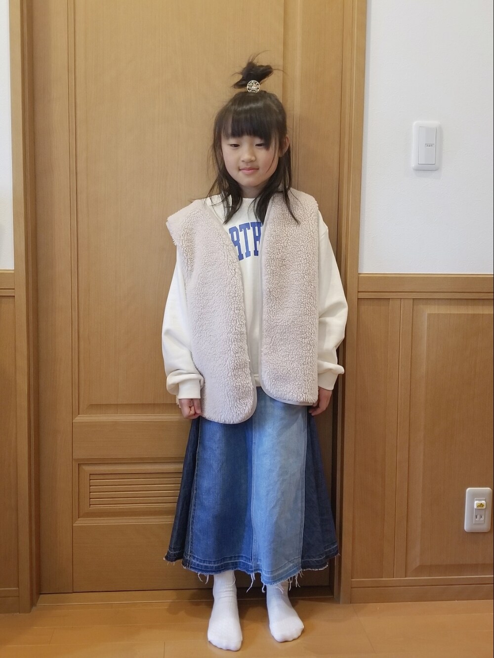 ホワイト系のスウェット、ブルー系のデニムスカートを着用したキッズの冬コーディネートの3枚目の写真