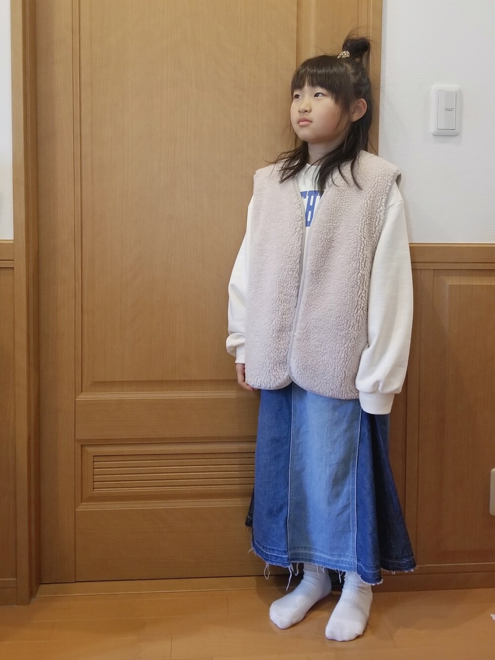 ホワイト系のスウェット、ブルー系のデニムスカートを着用したキッズの冬コーディネートの2枚目の写真