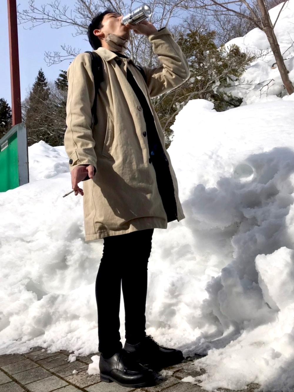 ブラック系のブーツ、ブラック系のデニムパンツ、ベージュ系のステンカラーコートを着用したメンズの冬コーディネートの2枚目の写真