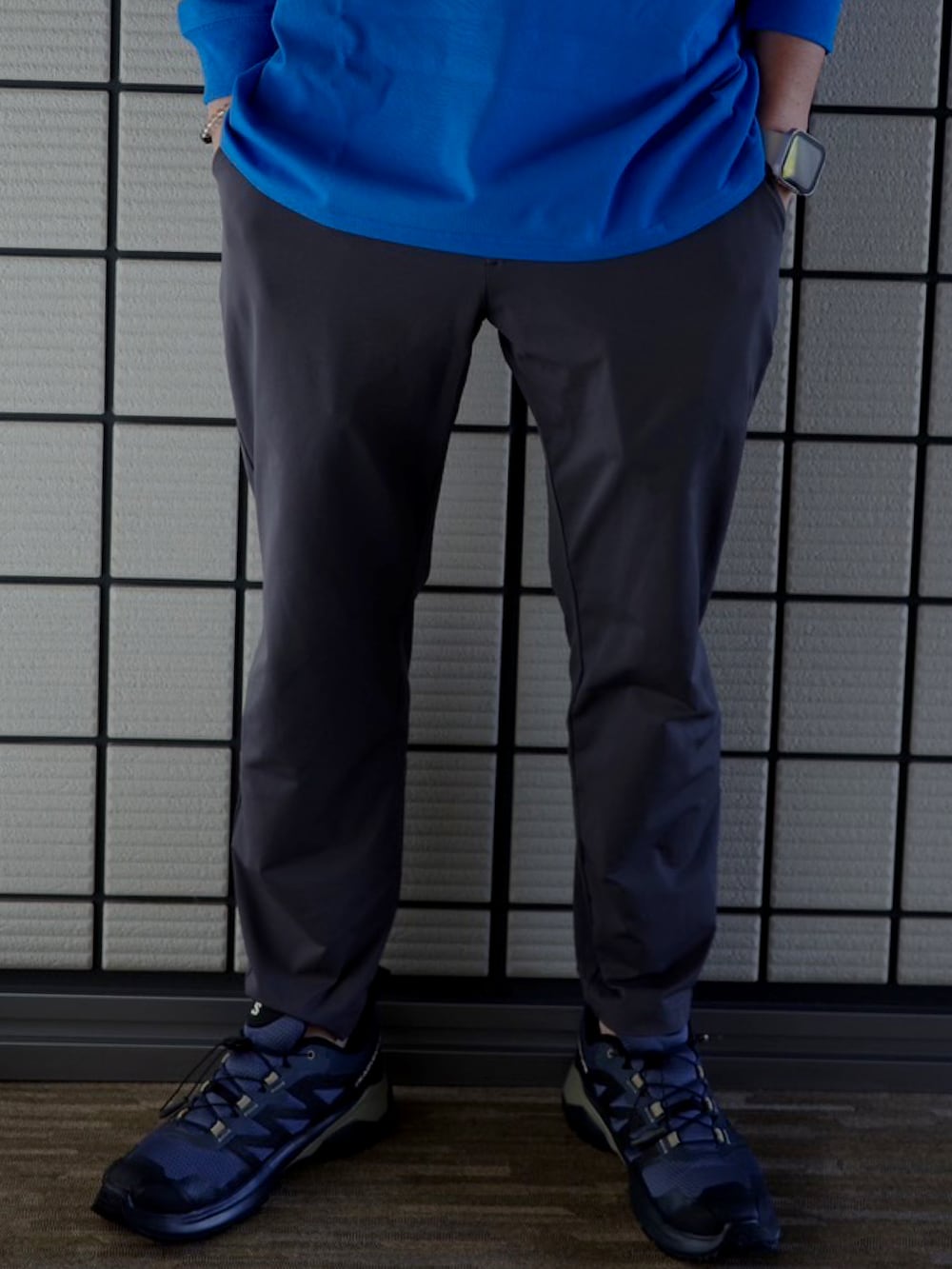 グレー系のパンツ、ブルー系のTシャツ/カットソー、ブラウン系のキャップを着用したメンズの秋コーディネートの2枚目の写真