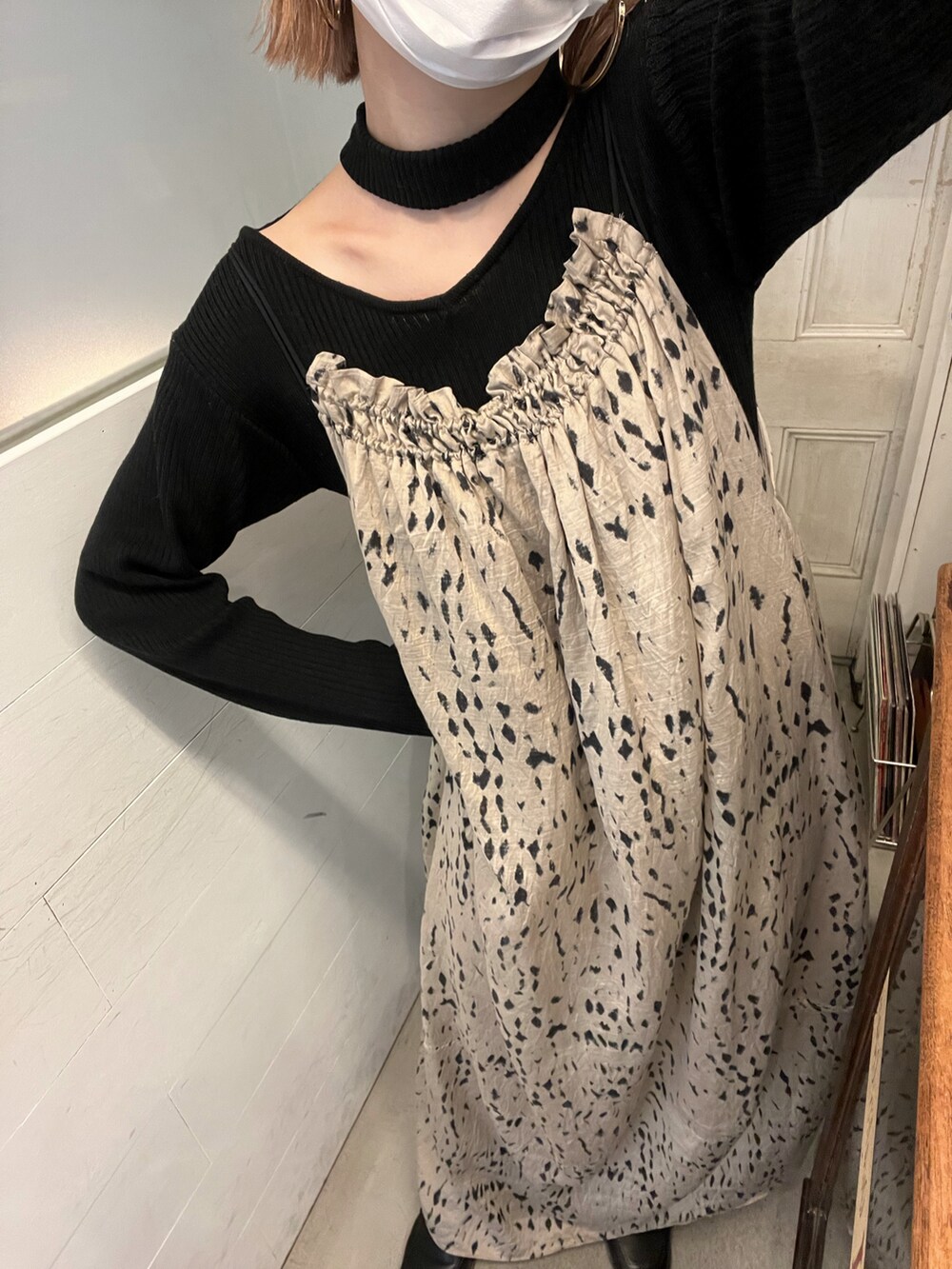 ベージュ系のワンピース/ドレス、ブラック系のトップスを着用したレディースの春コーディネートの2枚目の写真