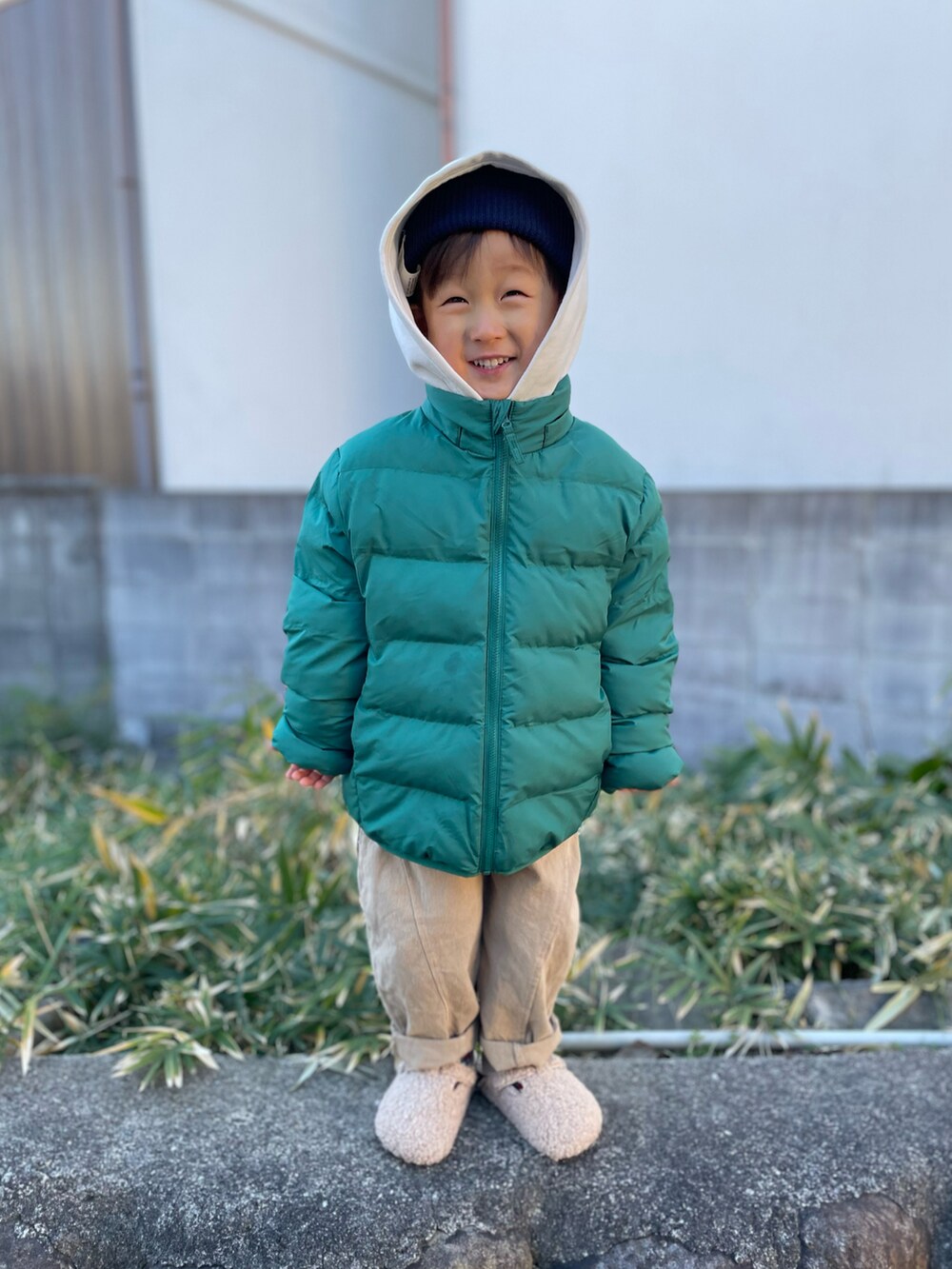 グリーン系のダウンジャケット/コート、ホワイト系のパーカー、ベージュ系のパンツを着用したキッズの冬コーディネートの3枚目の写真