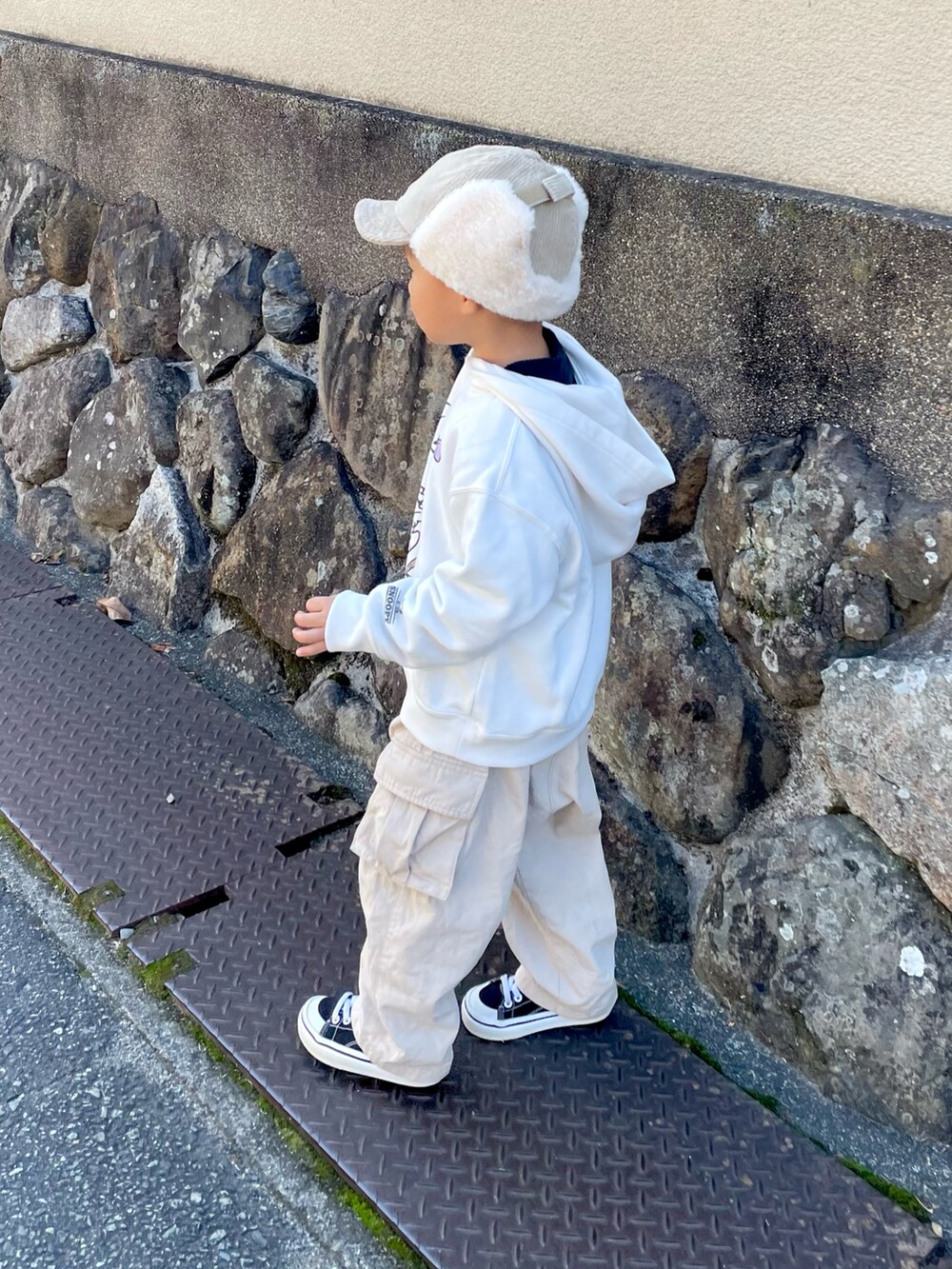 ホワイト系のパーカー、ベージュ系のその他パンツ、ブラック系のスニーカーを着用したキッズの秋コーディネートの3枚目の写真