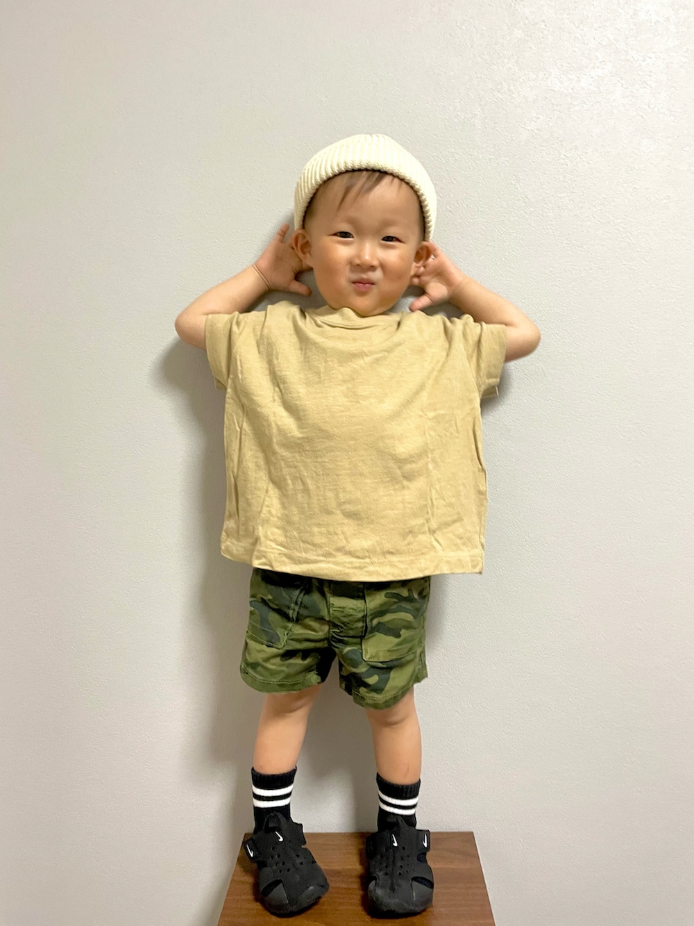 グリーン系のカーゴパンツ、ブラック系のサンダル、ホワイト系のニットキャップ/ビーニーを着用したキッズの春コーディネートの5枚目の写真