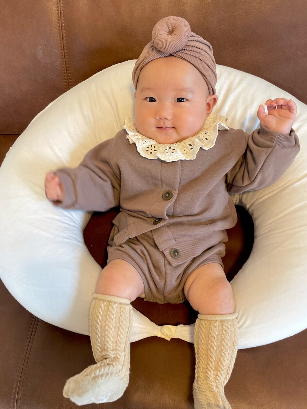 ブラウン系のその他ベビーウェア、ホワイト系のロンパース、ブラウン系のヘアバンドを着用したキッズの秋コーディネートの4枚目の写真