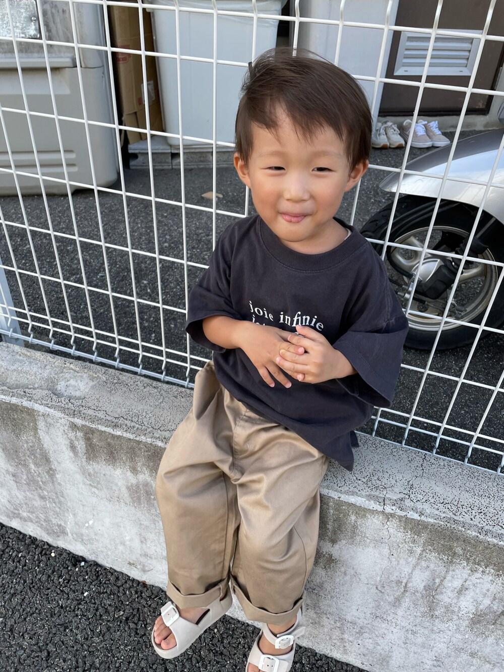 グレー系のTシャツ/カットソー、ベージュ系のチノパンツ、ベージュ系のサンダルを着用したキッズの夏コーディネートの5枚目の写真