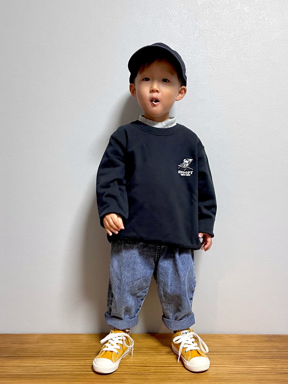 ブルー系のデニムパンツ、ブラック系のスウェット、ブラウン系のサンダルを着用したキッズの秋コーディネートの3枚目の写真