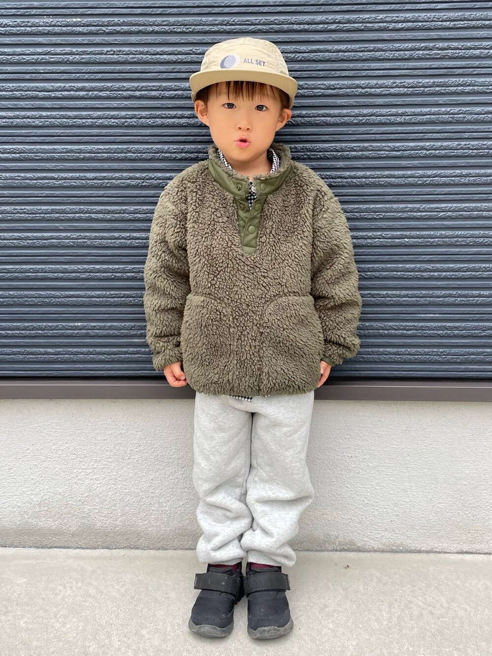 グリーン系のブルゾン、ブラック系のシャツ/ブラウス、ブラック系のスニーカーを着用したキッズの秋コーディネートの3枚目の写真