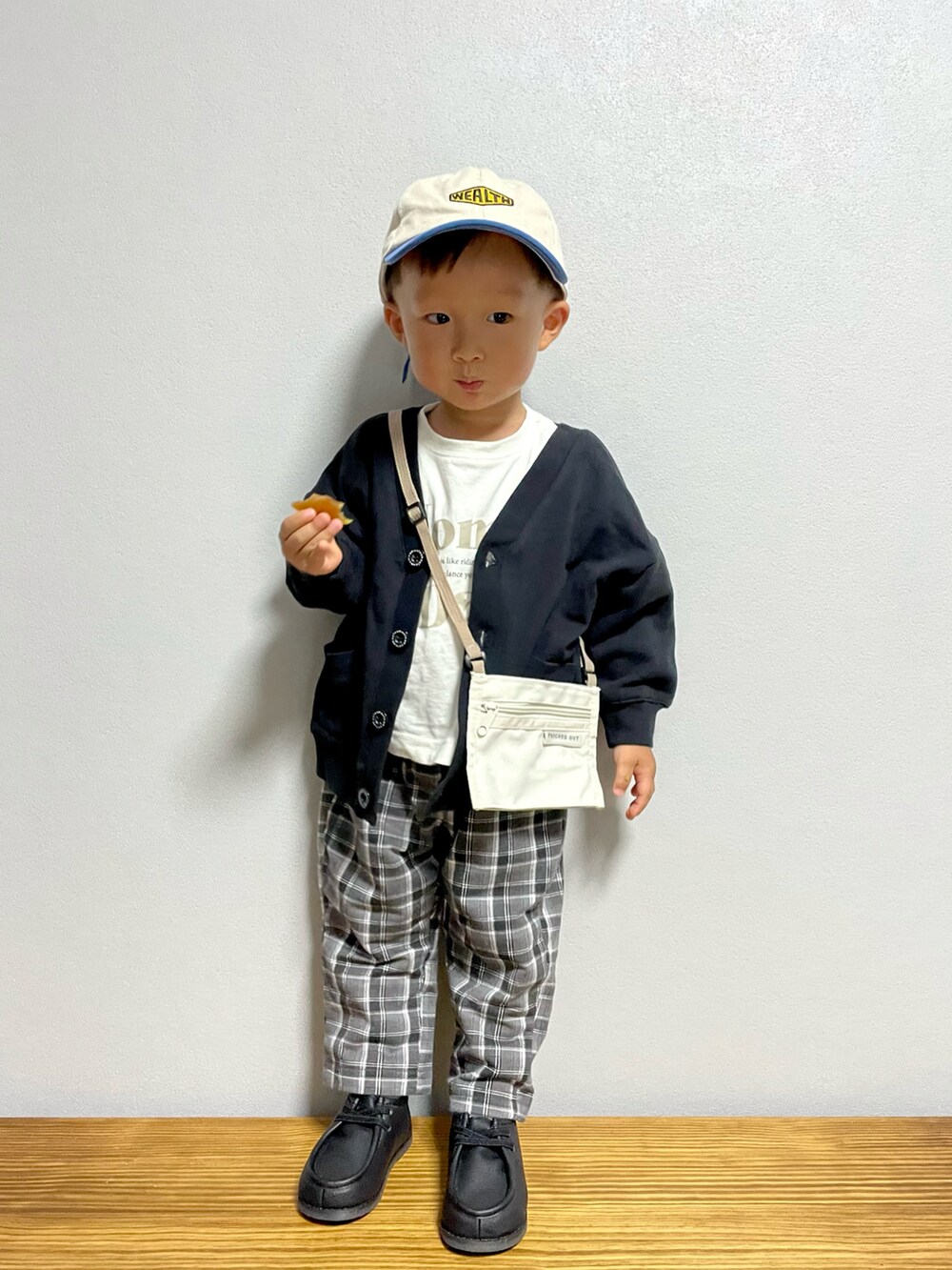 ベージュ系のTシャツ/カットソー、ブラック系のカーディガン/ボレロ、ブラック系のその他パンツを着用したキッズの秋コーディネートの2枚目の写真