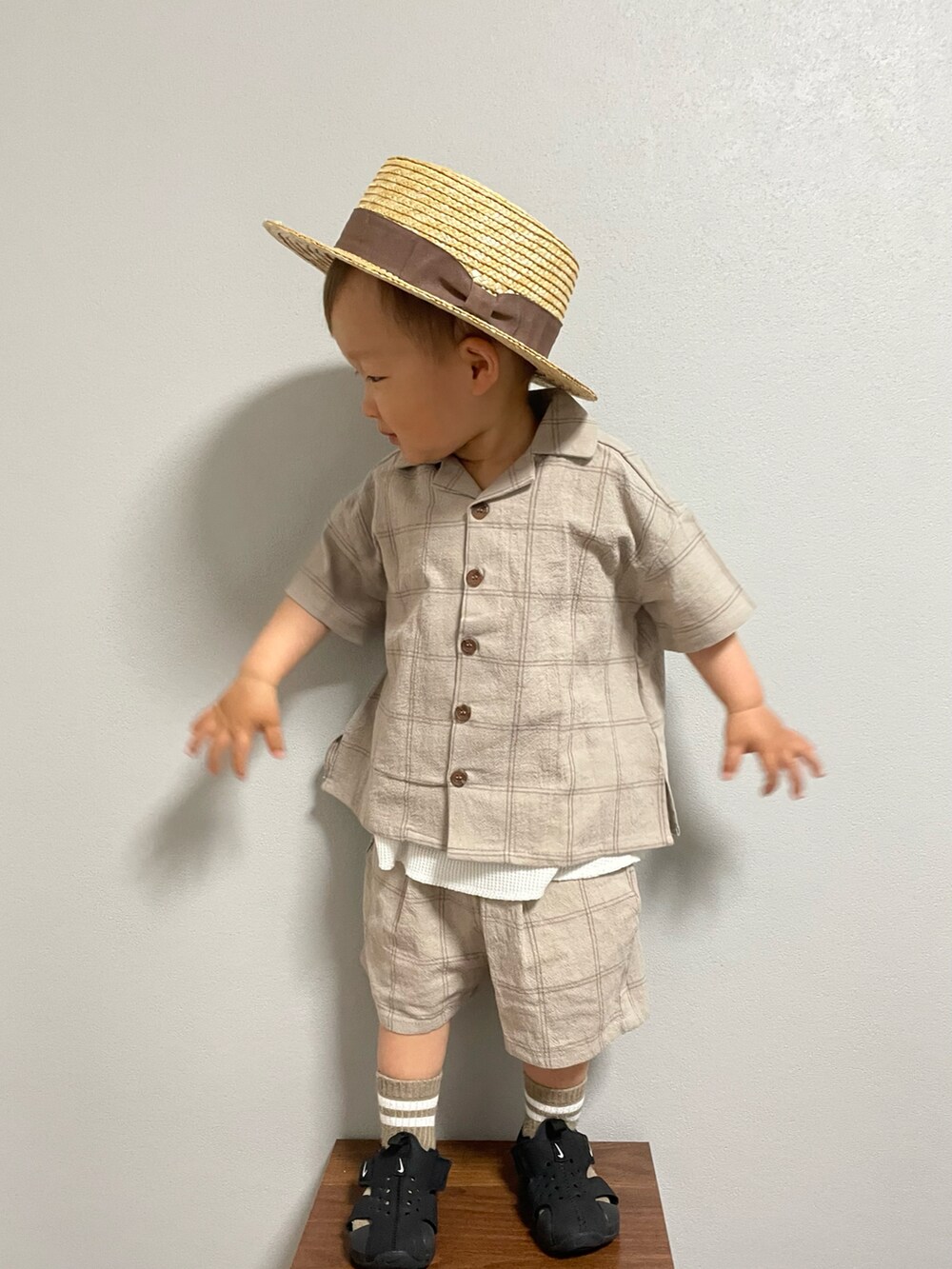 ブラック系のサンダル、ベージュ系のセットアップ、ホワイト系のタンクトップを着用したキッズの春コーディネートの4枚目の写真