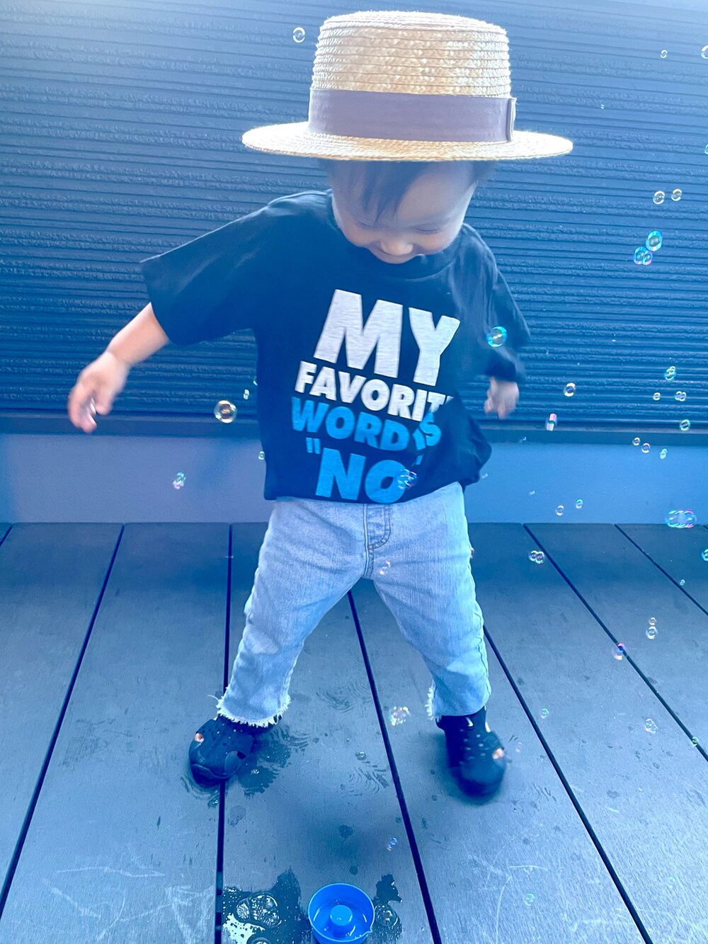 ブラック系のTシャツ/カットソー、ブルー系のデニムパンツ、ブラック系のサンダルを着用したキッズの夏コーディネートの2枚目の写真