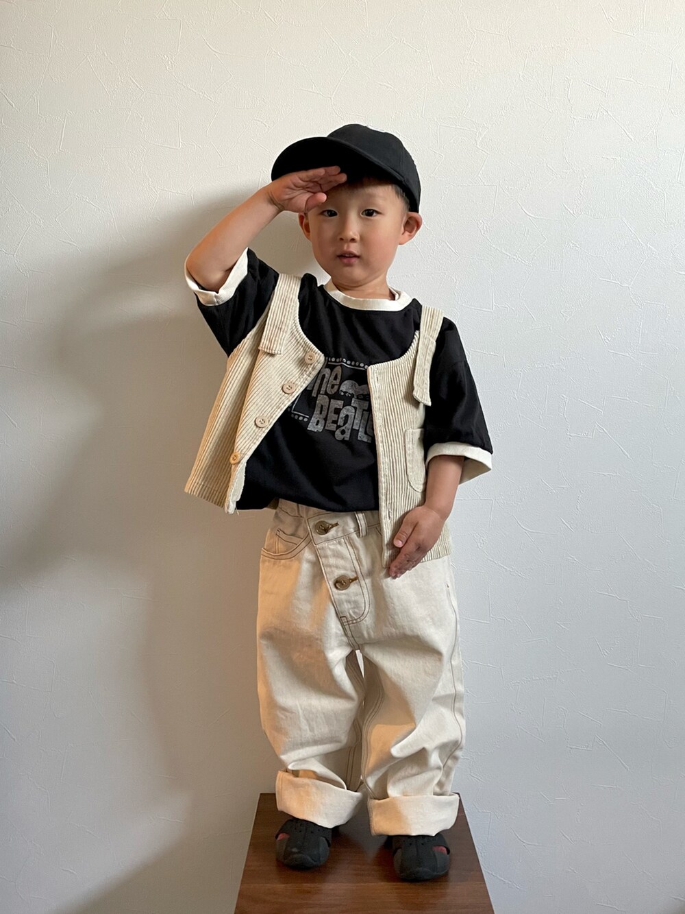 ブラック系のTシャツ/カットソー、ホワイト系のデニムパンツ、ブラック系のサンダルを着用したキッズの春コーディネートの3枚目の写真