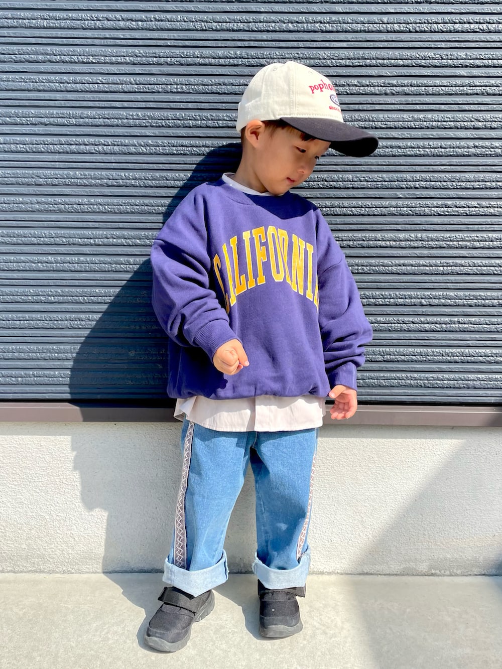 ブルー系のスウェット、ベージュ系のシャツ/ブラウス、ブルー系のデニムパンツを着用したキッズの秋コーディネートの2枚目の写真